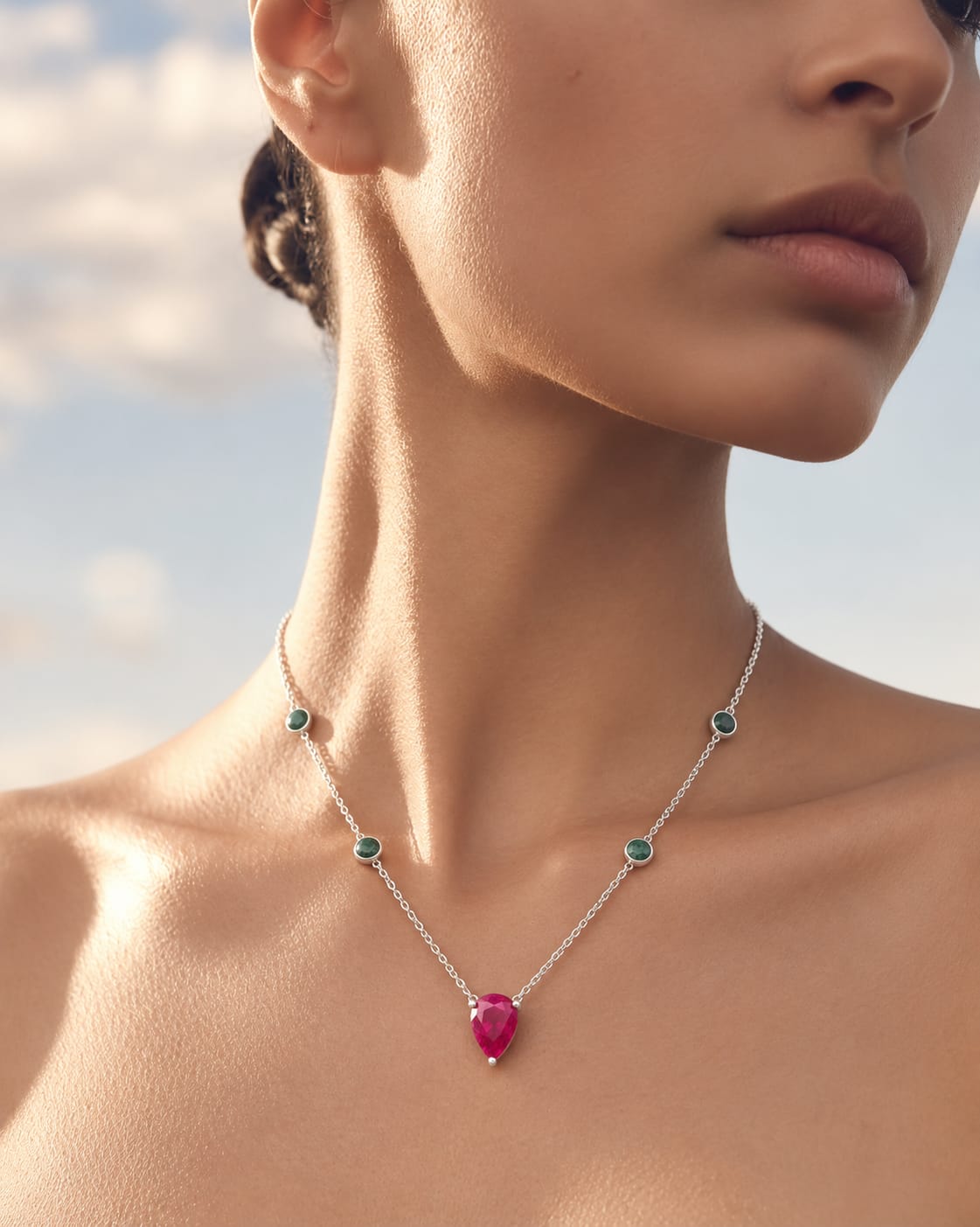 VIBELLA necklace with green accents and a pink pendant worn in sunlight